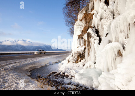 Le véhicule passe le long des falaises de glace Seward Highway, Southcentral Alaska, Winter Banque D'Images