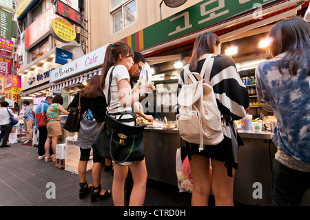 Les jeunes femmes de manger au food à Myeongdong, Séoul, Corée Banque D'Images