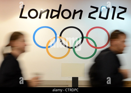 Les spectateurs quittent le Excel Arena et passé l'Anneaux olympiques de Londres 2012 Banque D'Images