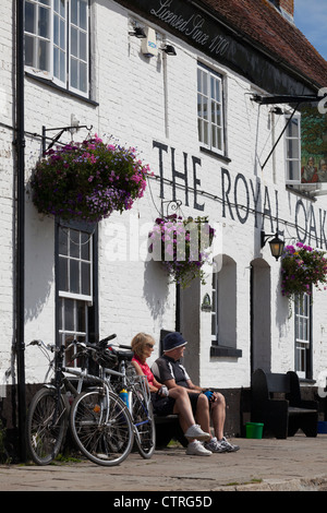 Cyclistics au repos assis sur un banc au soleil à l'extérieur de la Royal Oak Pub à Langston Banque D'Images