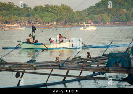 Les pêcheurs balinais retour au village d'Pemeuteran pour décharger leurs prises de la journée dans un outrigger bateaux de pêche. Banque D'Images