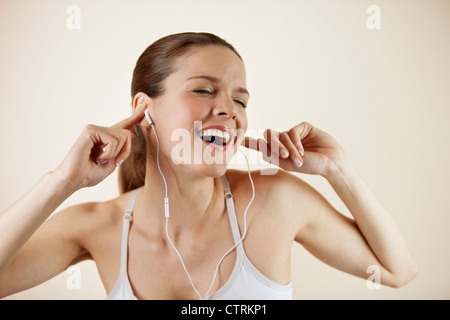 Une jeune femme portant des vêtements de fitness et d'écouteurs, écouter de la musique Banque D'Images