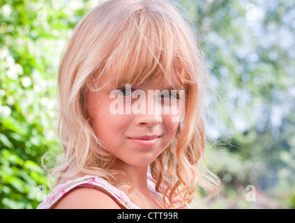 Portrait d'un sourire légèrement petite blonde magnifique jeune fille russe au-dessus de la nature de fond en plein air Banque D'Images