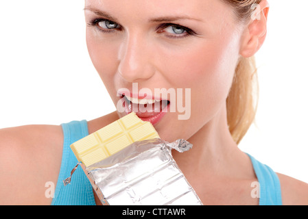 Femme mangeant une bar de chocolat blanc Banque D'Images