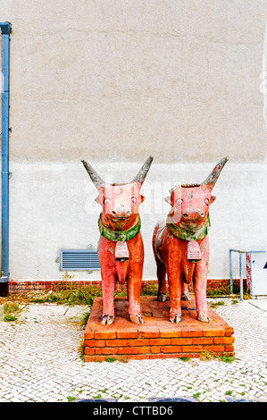 Deux statues en terre cuite de la détérioration des taureaux primitive sur un socle en brique rouge dans un jardin négligé, Santa Maria de Belém, Lisbonne Banque D'Images