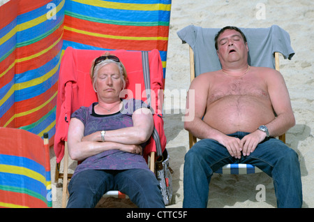 L'homme et la femme à dormir sur la plage de sable de St Ives cornwall uk Banque D'Images