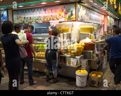 Hong Kong typique sur un kiosque de restauration rapide rue la nuit la vente de jus de fruits frais Banque D'Images