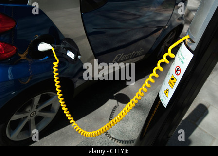 Voiture électrique recevant une charge à partir d'un stationnement de la ville affectés spéciaux bay, centre de Londres, au Royaume-Uni. Banque D'Images