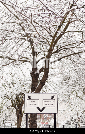 Panneau routier à Highgate, avec des arbres couverts de neige dans l'arrière-plan. Banque D'Images