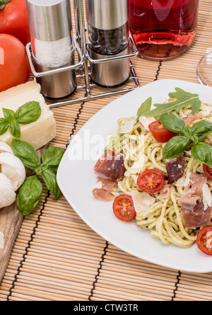 Spaghetti avec sauce pesto et les ingrédients à l'arrière-plan Banque D'Images