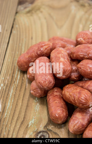 Un tas de mini saucissons sur fond de bois Banque D'Images