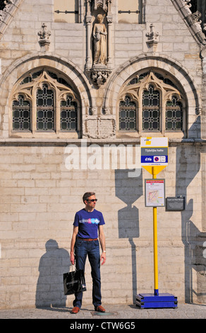 Leuven / Louvain, Belgique. St Pieterskerk / l'église Saint Pierre (15thC du gothique tardif). Homme debout à l'arrêt de bus temporaire Banque D'Images