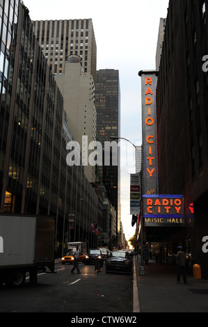 Portrait du matin, vers la 6ème Avenue, des phares des voitures, des camions de livraison de blanc, rouge neon Radio City, West 50th Street, New York Banque D'Images