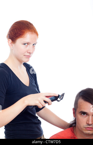 Coiffure femme aux cheveux longs de rasage tondeuse avec l'homme, isolé sur fond blanc avec copie grand espace. Banque D'Images