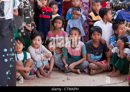 Le Myanmar, Birmanie. Bagan. Enfants birmans regardant une célébration Nat Pwe, remerciant les esprits pour une année de bonne fortune. Banque D'Images