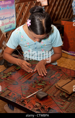 Le Myanmar, Birmanie. Bagan. Atelier de laques, femme au travail. Banque D'Images