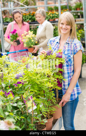 Smiling woman at garden center shopping pour les plantes Banque D'Images