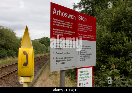 Téléphone et bilingue anglais Welsh - signes d'avertissement de passage à niveau dans les régions rurales en Pays de Galles Banque D'Images