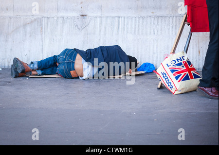 London Covent Garden Market man boy hommes jeunes trottoir chaussée couchage par l'église St Paul sur les sans-abri de cartons rugueux hobo tramp vagabonds Banque D'Images