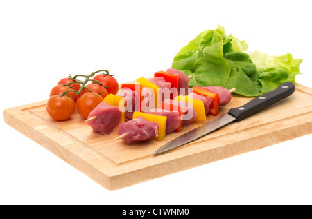 Brochettes de porc fraîchement préparés kebab sur une planche à découper en bois - profondeur de champ - studio photo avec un fond blanc Banque D'Images