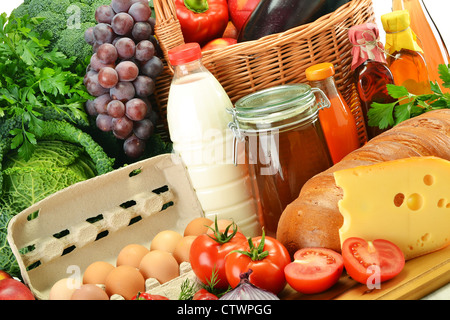 Épicerie dans panier en osier dont les légumes, les fruits, les produits de boulangerie et des produits laitiers et du vin isolated on white Banque D'Images
