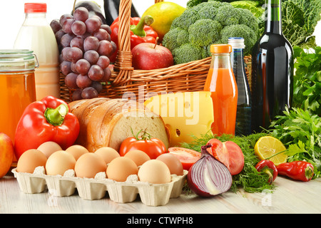 Épicerie dans panier en osier dont les légumes, les fruits, les produits de boulangerie et des produits laitiers et du vin isolated on white Banque D'Images