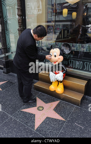 Un membre du personnel au Studio stocke jusqu'touche Mickey Mouses" nez sur le Hollywood Walk of Fame sur Hollywood Boulevard Banque D'Images