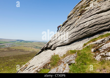 Homme d'escalade sur les roches Haytor, d'un granit tor sur le Dartmoor, Devon, UK Banque D'Images