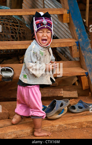 Une petite fille de la tribu AKHA porte une headdresse childs fait de perles, d'argent et tissés main coton - KENGTUNG, MYANMAR Banque D'Images