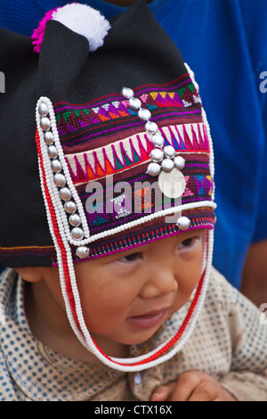 Une petite fille de la tribu AKHA porte une headdresse childs fait de perles, d'argent et tissés main coton - KENGTUNG, MYANMAR Banque D'Images