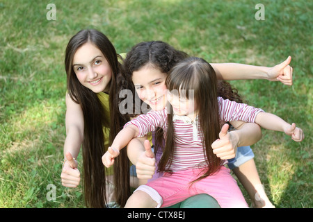 Happy girls giving Thumbs up dans le parc. Banque D'Images