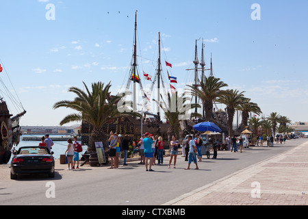 Quay avec quelques touristes et des vieux navires stylisés dans le port de ville de Sousse, Tunisie, Afrique Banque D'Images