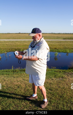 Guide Local Sam Faulk démontre un GPS de poche Ranger video tour appareil, Creole Nature Trail/All-American Road, LA, USA Banque D'Images
