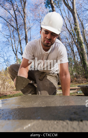 À l'aide d'une truelle pour Hispanic carpenter le béton lisse pour escalier d'égalité Banque D'Images