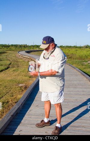 Guide Local Sam Faulk démontre un GPS de poche Ranger video tour appareil, Creole Nature Trail/All-American Road, LA, USA Banque D'Images