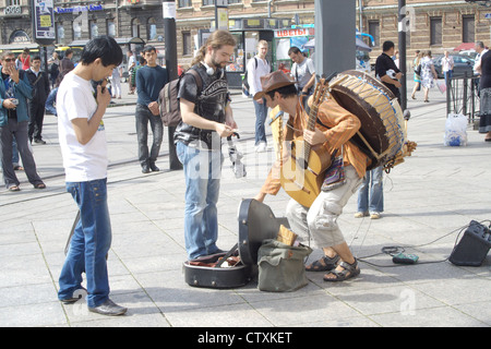 Les gens à l'écoute de la performance d'un musicien de rue péruvien le 05 août 2012 à Saint-Pétersbourg, Russie Banque D'Images