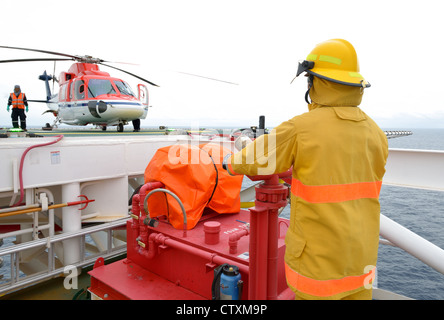 Pompier est la garde d'offshore helicopter avant de démarrer le moteur. Banque D'Images