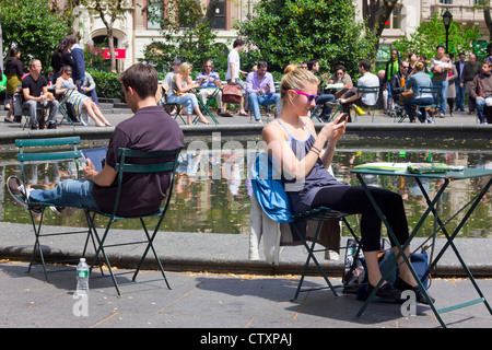 Les gens de Madison Square Park, à New York le jour de printemps sur les appareils électroniques Banque D'Images