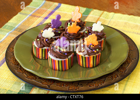 Vanilla cupcakes avec ganache chocolat décoré avec des feuilles de chocolat pour les fêtes d'automne Banque D'Images