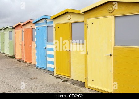 Cabines de plage de couleur pastel sur la promenade à Seaford dans l'East Sussex, Angleterre. Banque D'Images