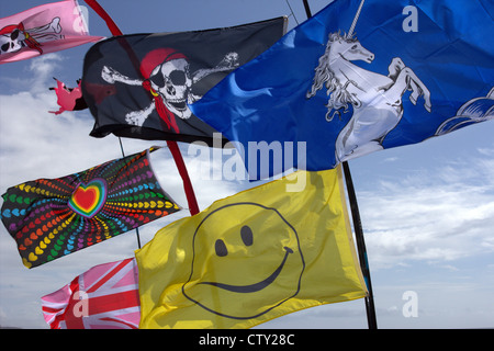 Des drapeaux aux couleurs vives avec divers dessins psychédéliques dans le vent sur une journée ensoleillée Banque D'Images