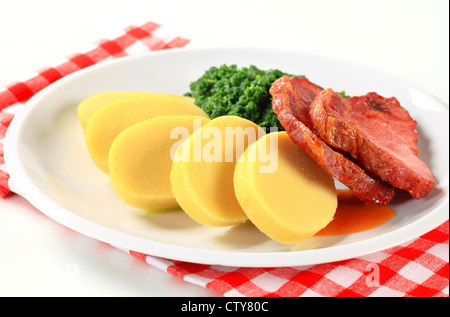 Cou de porc fumé rôti Pan avec boulettes de pommes de terre et épinards Banque D'Images