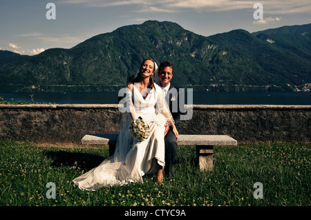 Bride and Groom posing sur un banc de parc en plus du Lac de Côme en Italie Banque D'Images