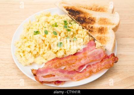 Petit-déjeuner d'œufs brouillés avec bacon et des tranches de pain grillé - studio shot Banque D'Images