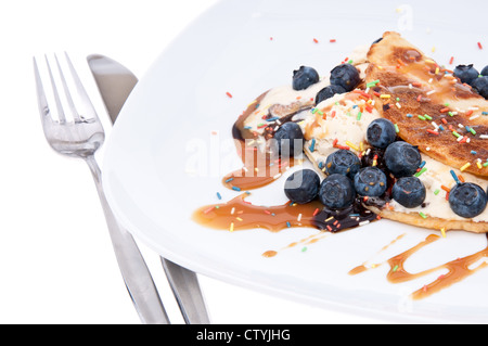 Crème glacée à la vanille décoré avec des bleuets et surmontée de sirop de caramel isolé sur fond blanc Banque D'Images