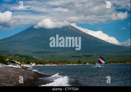 Un bateau de pêche balinaise sous voiles dans le domaine de l'Jemeluk Amed, Bali, Indonésie. Le volcan Mt. Agung est dans l'arrière-plan. Banque D'Images