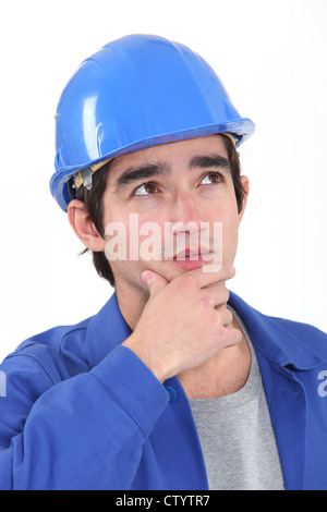 Pensive young builder recherche d'inspiration Banque D'Images