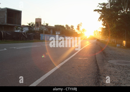 Sun shining on rural road Banque D'Images