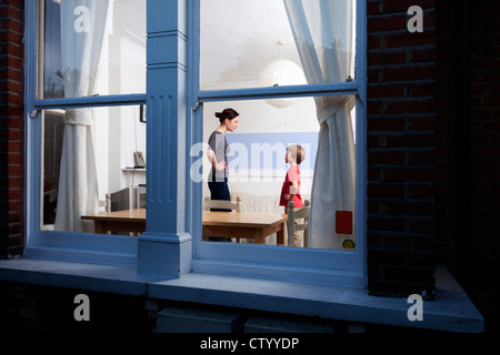 Mère et fils vue à travers la vitre Banque D'Images