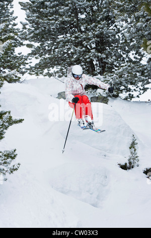 Skier jumping on snowy slope Banque D'Images